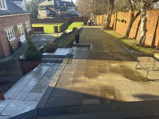 Before: large tiered back garden with a paved terrace, steps and paths beside a brick house